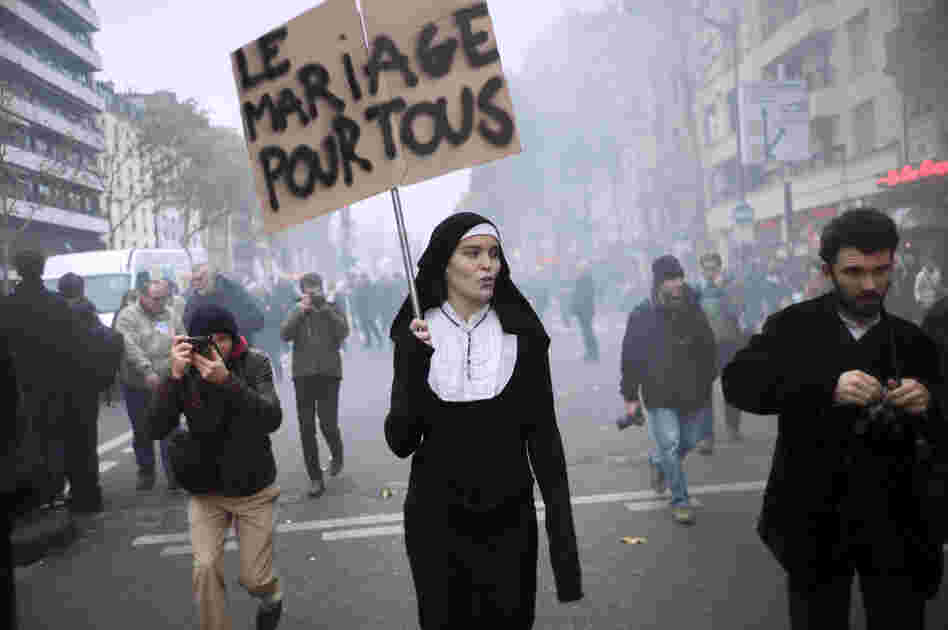 A woman holds a sign 