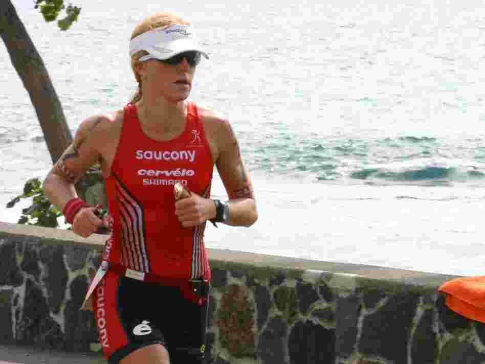 Sarah Piampiano holds two energy gels, one with caffeine and one without, as she runs in this year's Ironman World Championship.