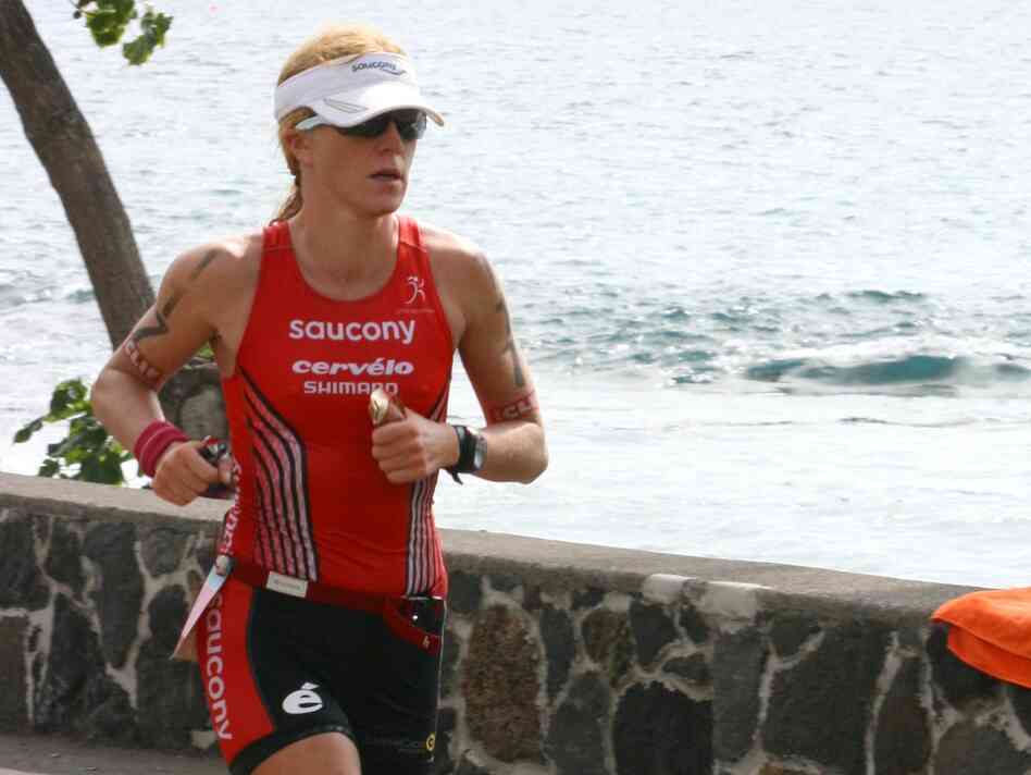 Sarah Piampiano holds two energy gels, one with caffeine and one without, as she runs in this year's Ironman World Championship.