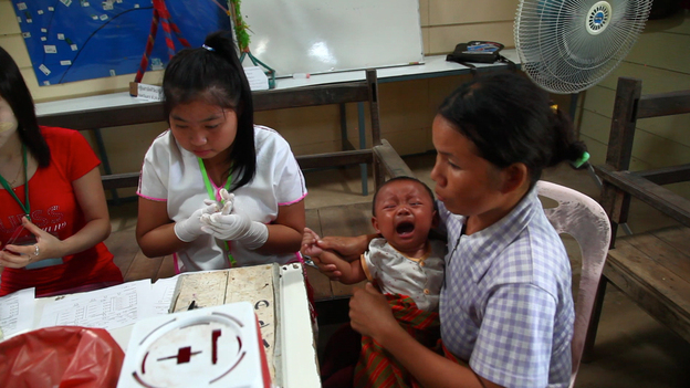Health workers take a blood sample from an infant to test for the malaria at a clinic along the border between Thailand and Myanmar.
