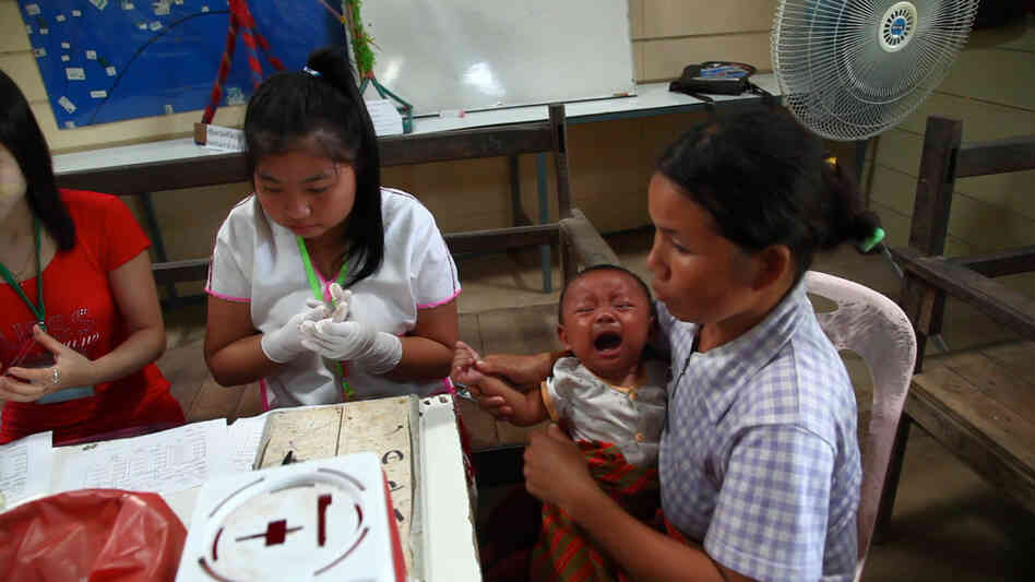 Health workers take a blood sample from an infant to test for the malaria at a clinic along the border between Thailand and Myanmar.