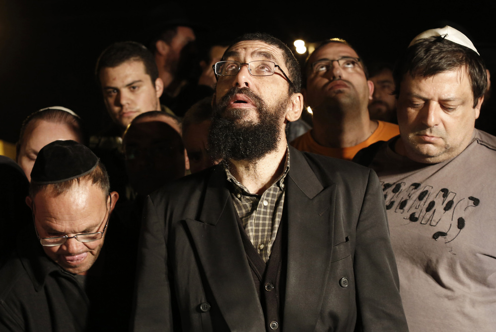 Family and friends of Aaron Smadja, one of the three Israelis killed by a rocket fired from Gaza, mourn during his funeral at a cemetery in the southern Israeli town of Kiryat Malachi on Thursday.