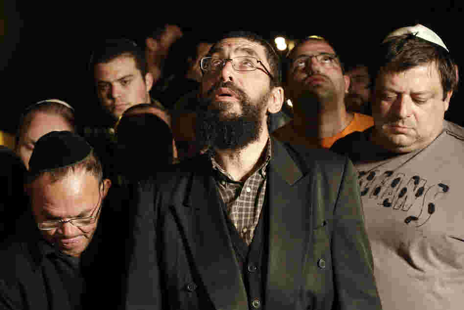 Family and friends of Aaron Smadja, one of the three Israelis killed by a rocket fired from Gaza, mourn during his funeral at a cemetery in the southern Israeli town of Kiryat Malachi on Thursday.