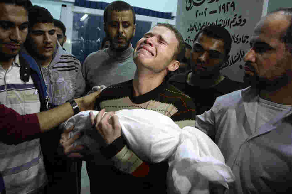Jihad Masharawi weeps while he holds the body of his 11-month old son Ahmad, at Shifa hospital following an Israeli air strike on their family house, in Gaza City on Wednesday.