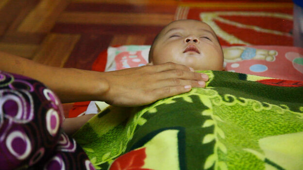 A mother comforts her sick child at the Whampa malaria clinic on the Thailand-Burma border. Children under 5 years of age are especially vulnerable to the disease.