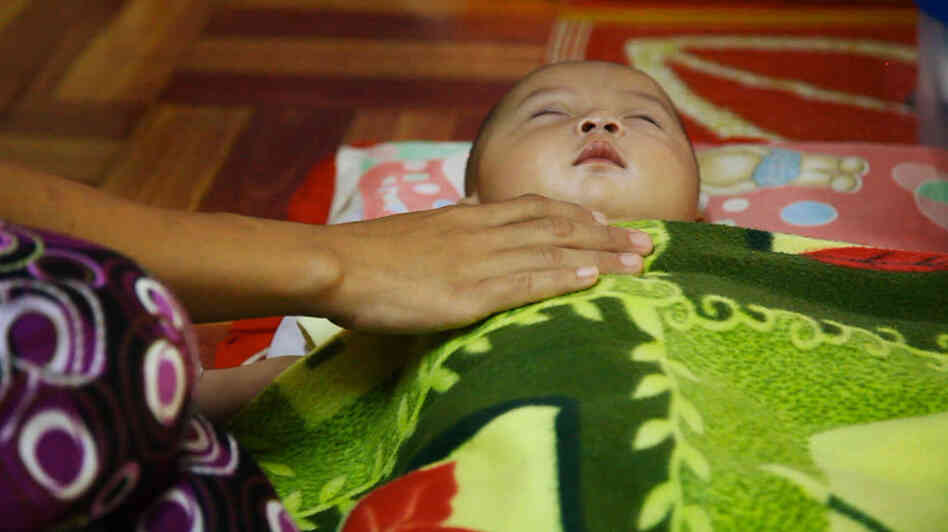 A mother comforts her sick child at the Whampa malaria clinic on the Thailand-Burma border. Children under 5 years of age are especially vulnerable to the disease.