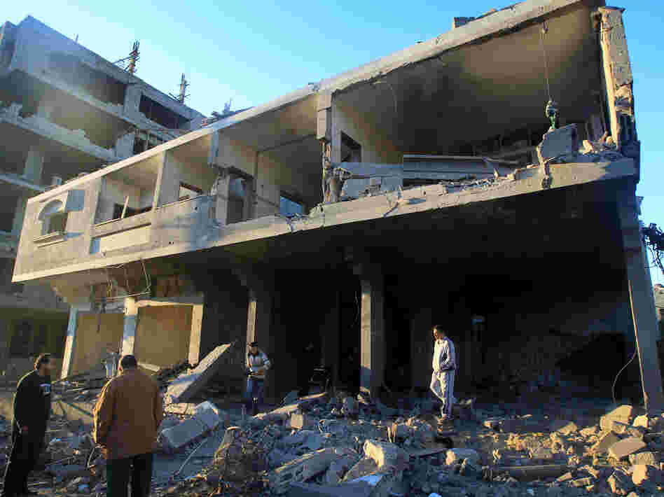 Palestinians inspect a destroyed building in an area targeted by an Israeli air strike in Gaza City earlier today.