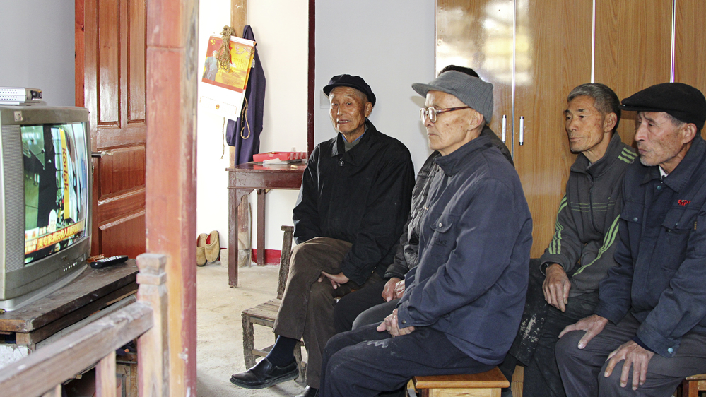 Villagers in Dongjiangai, in eastern China's Jiangsu province, watch the presentation of the Communist Party's new leadership on national TV Thursday. They say they support the new leaders because of the improvements government policies have brought to their village.