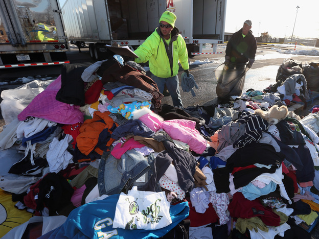 James Vouloukos (left) and William Ferris sort through donated clothes in Oceanside, N.Y. Relief workers say cash is more useful than donated supplies for their efforts.