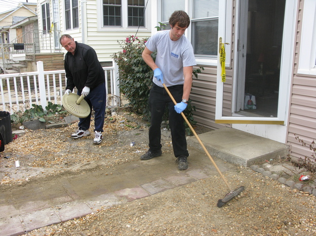 Wayne Duszczak (left) and his son Anthony clean up the gravel yard of their Seaside Heights home, which was badly damaged during Superstorm Sandy.