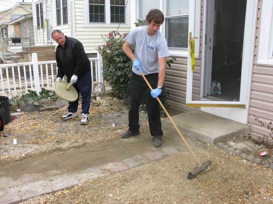 Wayne Duszczak (left) and his son Anthony clean up the gravel yard of their Seaside Heights home, which was badly damaged during Superstorm Sandy.