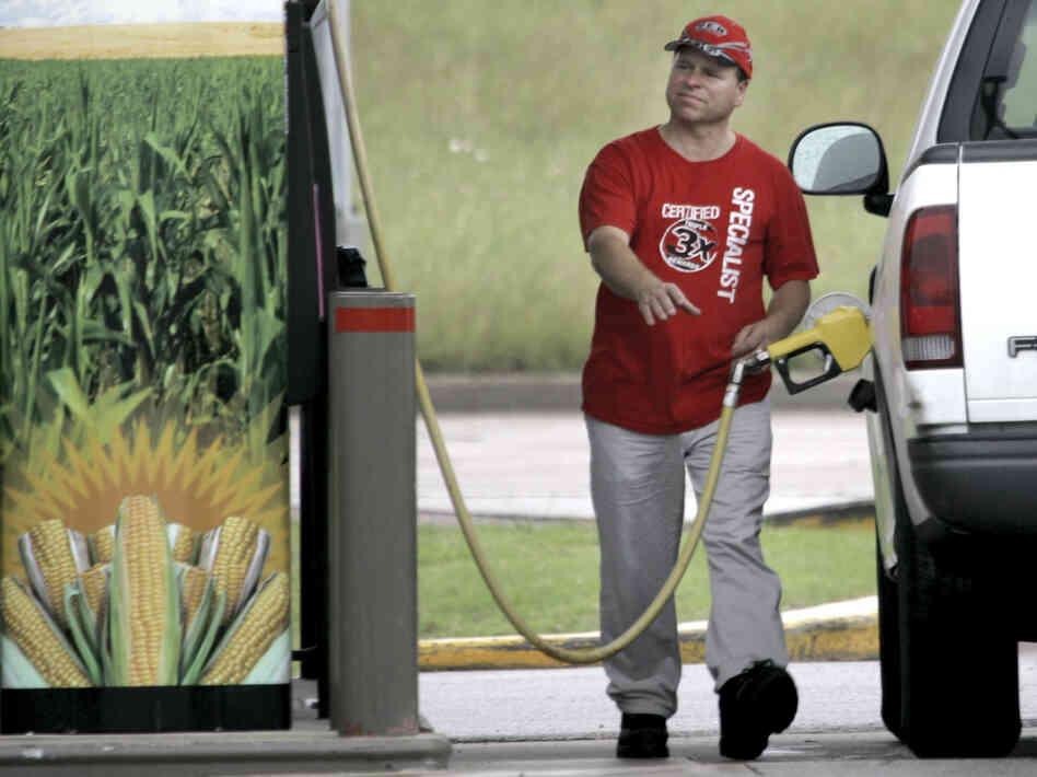 A sign on the pump advertises the ethanol content of the gasoline as a motorist reaches for the gas pump in his truck at a filling station in Bellmead, Texas.