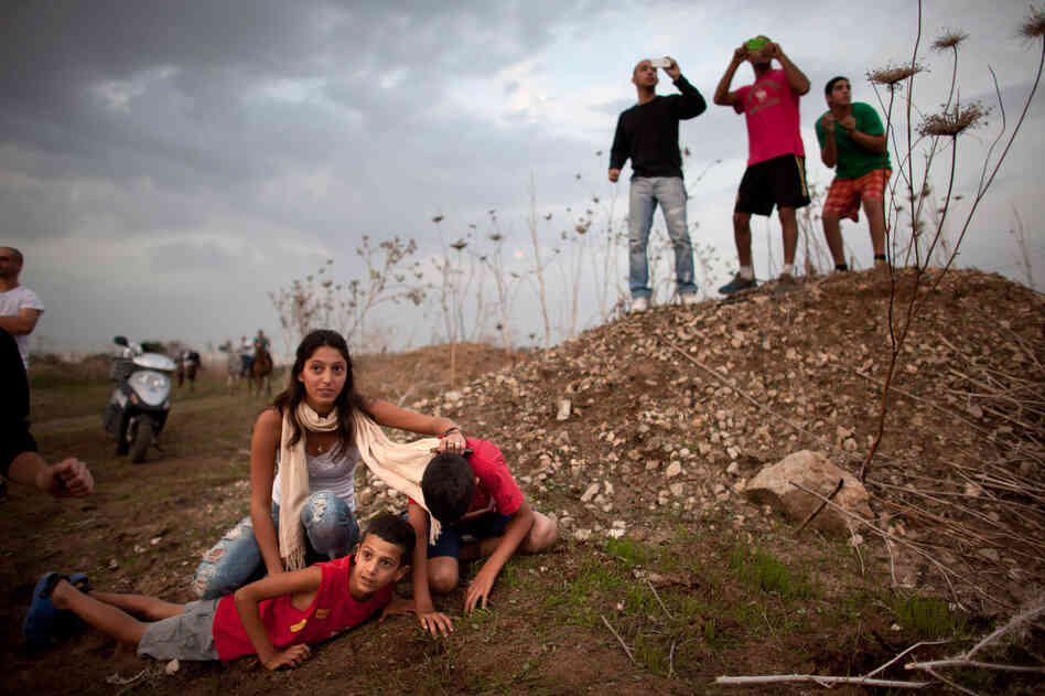 Israeli civilians in Tel Aviv run for cover during a rocket attack launched from Gaza on Saturday.