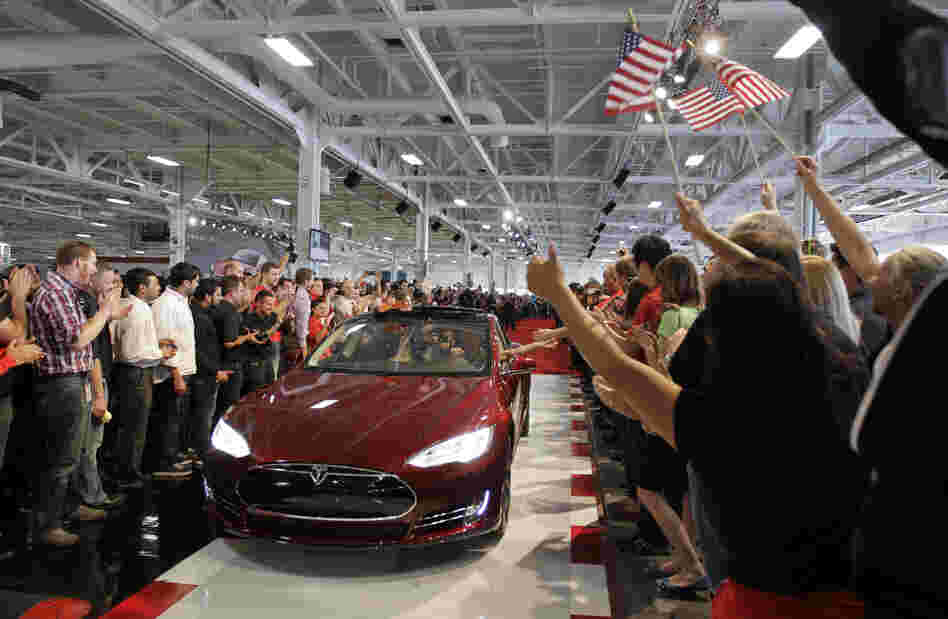 Tesla workers cheer on the first Tesla Model S cars sold during a rally at the Tesla factory in Fremont, Calif., in June.