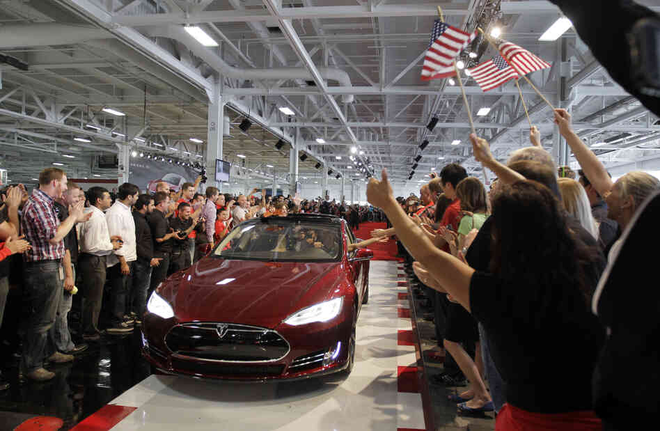 Tesla workers cheer on the first Tesla Model S cars sold during a rally at the Tesla factory in Fremont, Calif., in June.