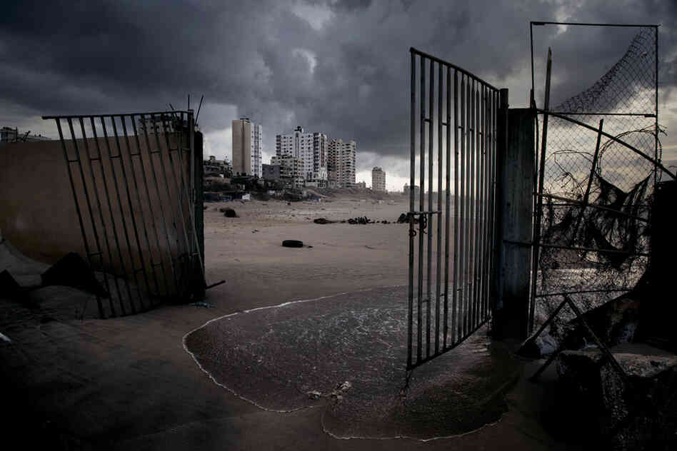 Gaza City apartments rise beyond the broken gates of a waterfront restaurant. The beach once bustled with fishing boats and cafes, but the Israeli naval blockade, sewage and lack of resources for rebuilding have taken their toll.