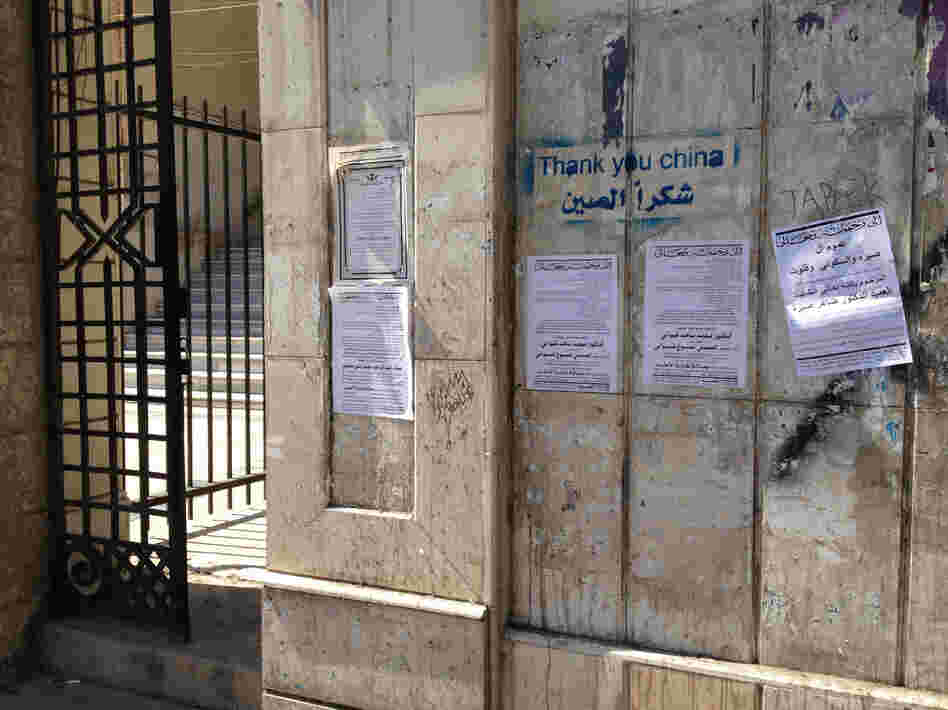 Death notices hang on a wall alongside pro-regime graffiti in central Damascus.