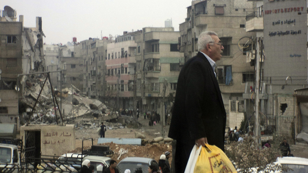 A man walks near buildings damaged after shelling by forces loyal to Syria's President Bashar Assad, at Harasta, a suburb of Damascus, on Nov. 19.