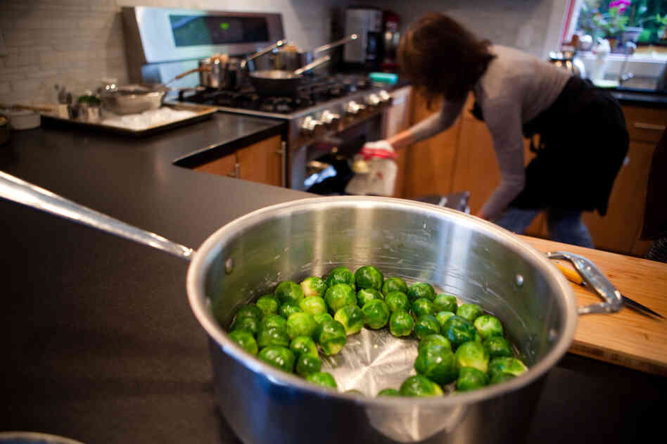 Food stylist Lisa Cherkasky, who cooked most of the meal in advance of the taping, checks the temperature on the oven. The trick to Child's Brussels sprouts is to blanch them first, then cut off the ends and place them flat on the bottom of the pan so they soak up all the butter.