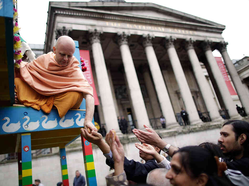 A Hare Krishna distributes food gifts from a chariot during a festival in London in 2011. The religious group began distributing books, flowers and gifts to strangers in the 1970s, drawing on the rule of reciprocation to raise money.