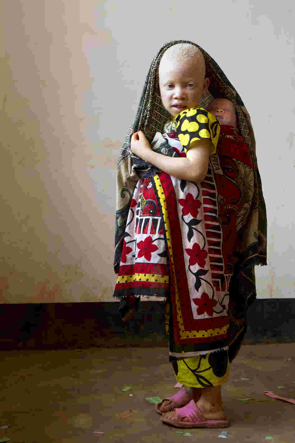 Lightness, age unknown, holding baby Jessica, 3 months old. Lightness was abandoned at the center, and Jessica came with her mother after they were threatened with attack. Jessica's older brothers also live at the center since the eldest was physically attacked at their home.