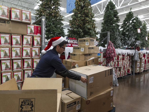 Walmart associate Angel Campos stocks Christmas decorations Wednesday ahead of the pre-Black Friday event at the Wal-Mart Supercenter store in Rosemead, Calif.