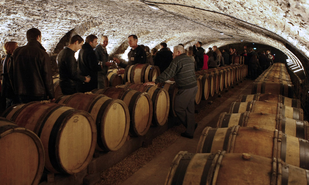 Guests attend a wine tasting in the cellar of Hotel Dieu before the wine auction.