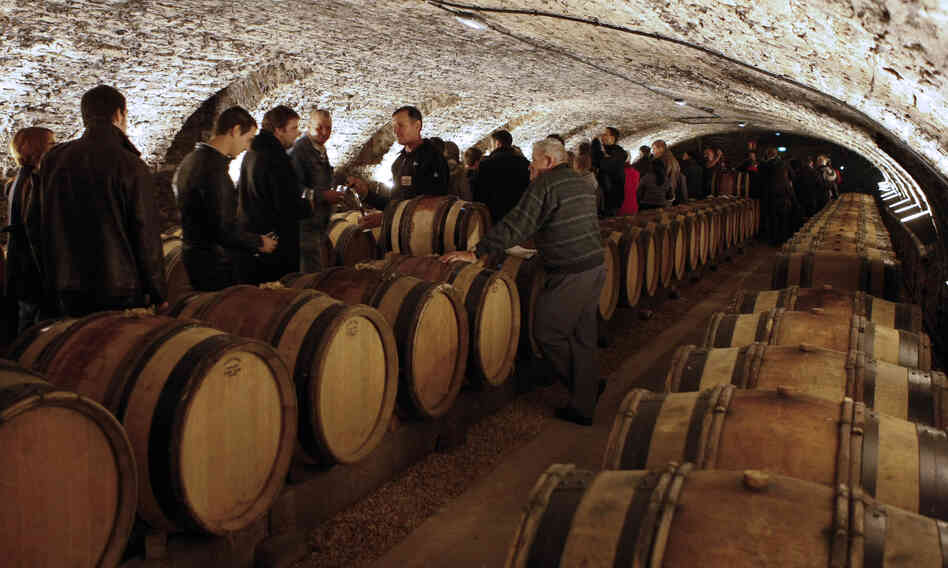 Guests attend a wine tasting in the cellar of Hotel Dieu before the wine auction.