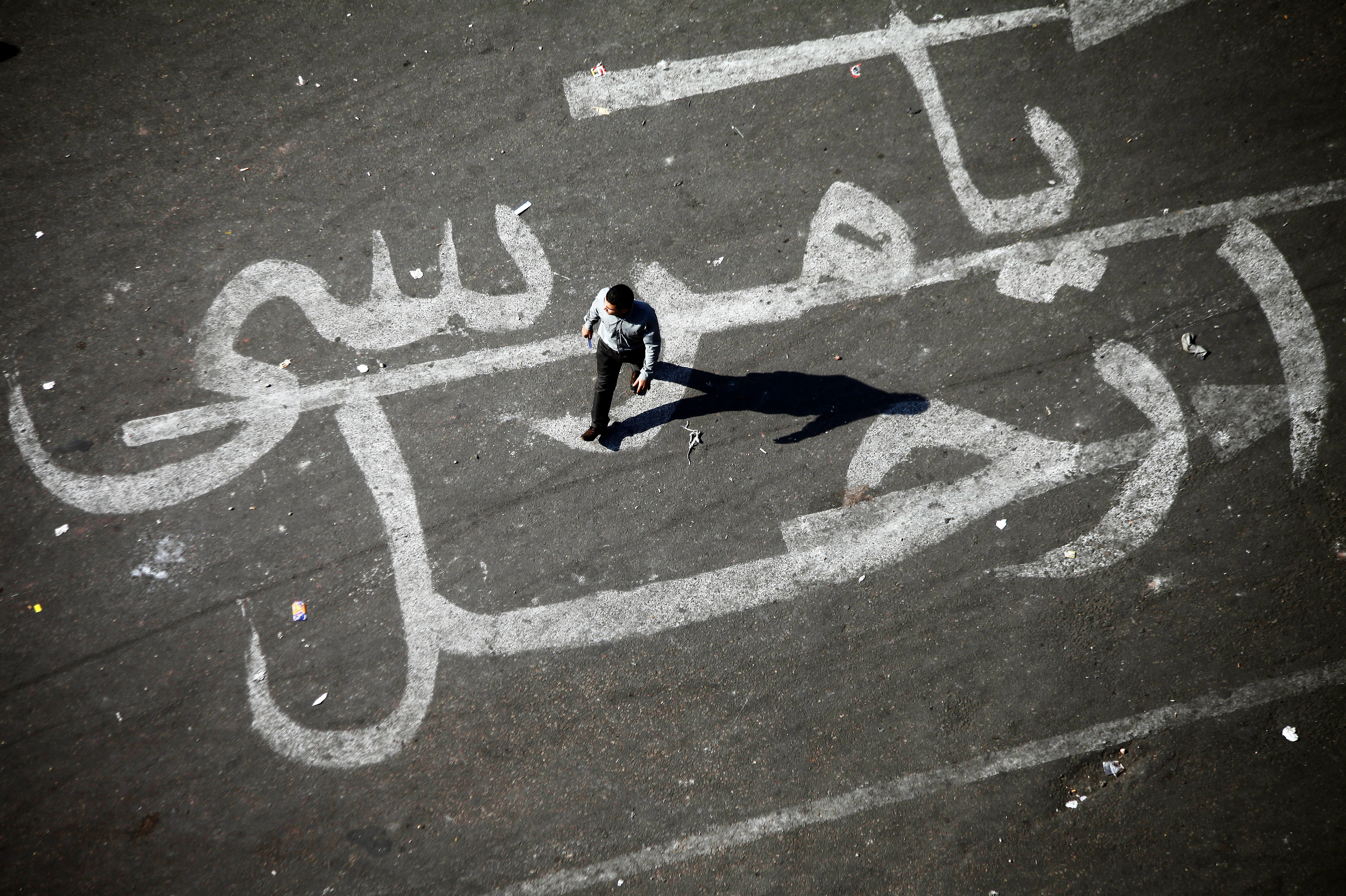 An Egyptian man walks over a graffiti reading "Morsi Go" at Egypt's landmark Tahrir square in Cairo. An Egyptian man walks over a graffiti reading "Morsi Go" at Egypt's landmark Tahrir square in Cairo.
