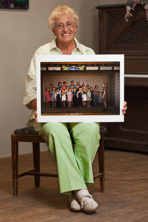 Kathryn Roberts at the Pie Town Community Center (formerly the Farm Bureau), holding the photo of her class singing