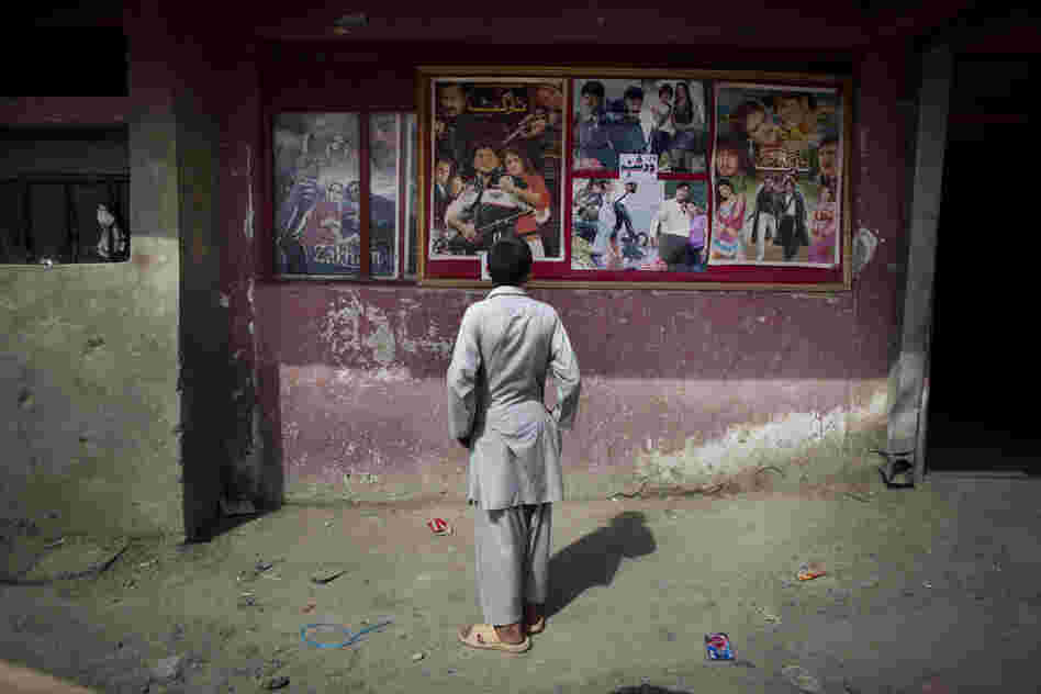 A young Afghan boy looks at movie posters outside Temorshahee Cinema in Kabul. Going to the movies, once banned under the Taliban, has become a popular form of entertainment in Kabul, but women and children rarely take part.