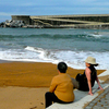 Residents of Mutriku, a fishing village on Spain's northern coast, lounge at their local beach, protected from fierce Atlantic waves by a cement breakwater that also houses Europe's first wave energy plant.