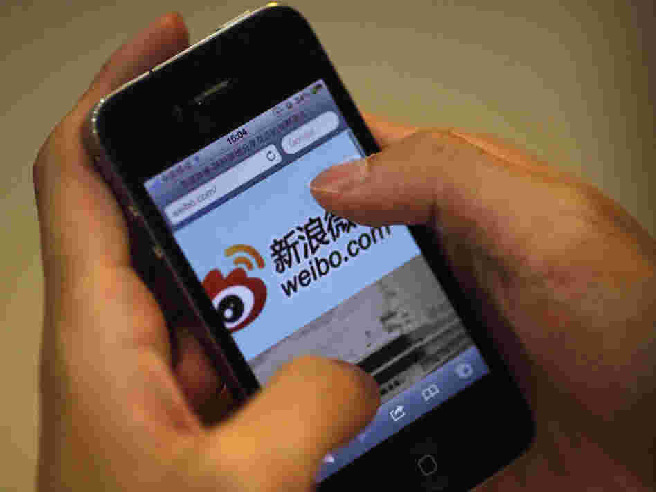 A man holds an iPhone as he visits Sina's Weibo microblogging site in Shanghai earlier this year.