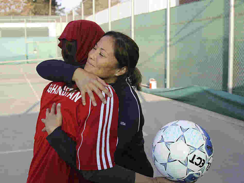 Former U.S. Olympian Lorrie Fair hugs Zahra Mahmoudi, the captain of the Afghan women's soccer team.