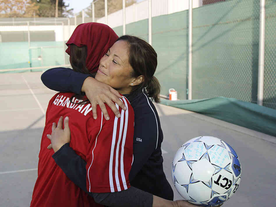 Former U.S. Olympian Lorrie Fair hugs Zahra Mahmoudi, the captain of the Afghan women's soccer team.