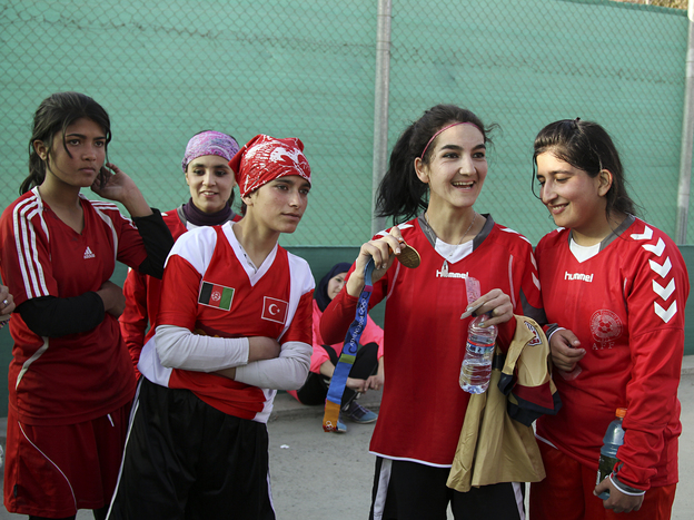 Afghan soccer player Hadissa Wali holds the Olympic medal belonging to former U.S. player Lorrie Fair.