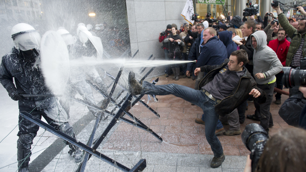 European dairy farmers spray police officers with milk during a demonstration outside the European Parliament in Brussels on Monday.