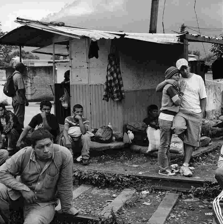 Migrants wait for a train by the tracks in the city of Orizaba in the Mexican state of Veracruz. There is no migrant shelter in Orizaba, and migrants wait out in the open, often for days, to catch moving freight trains. July 2010.