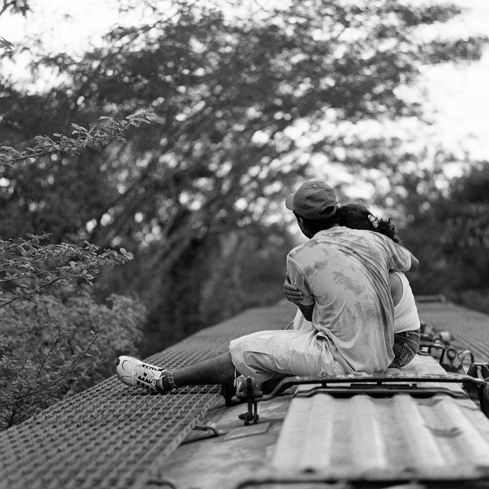A Guatemalan migrant couple embraces on top of a northbound freight train while traveling through the Mexican state of Chiapas. June 2009.