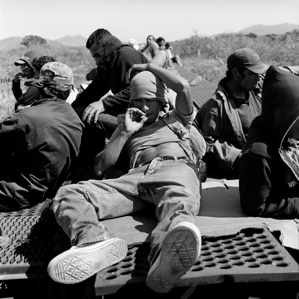 Migrants ride atop a freight train through Oaxaca. February 2011.