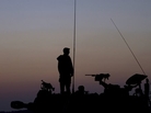 After a week of recent fighting between Israel and Hamas, an Israeli soldier stands on top of a mobile artillery unit in a position near the Israel Gaza border. After a week of recent fighting between Israel and Hamas, an Israeli soldier stands on top of a mobile artillery unit in a position near the Israel Gaza border.