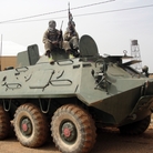 Fighters of the Islamist group, the Movement for Oneness and Jihad in West Africa guard a tank abandoned by the Malian army on Aug. 7.