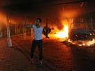 An armed man waves his rifle as buildings and cars are engulfed in flames after being set on fire inside the U.S. Consulate compound in Benghazi late on Sept. 11. An armed man waves his rifle as buildings and cars are engulfed in flames after being set on fire inside the U.S. Consulate compound in Benghazi late on Sept. 11.