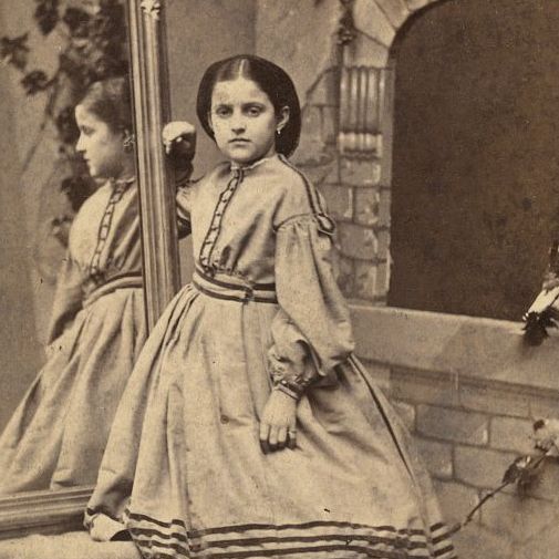 Rebecca Huler's poses next to a mirror with reflects her profile.