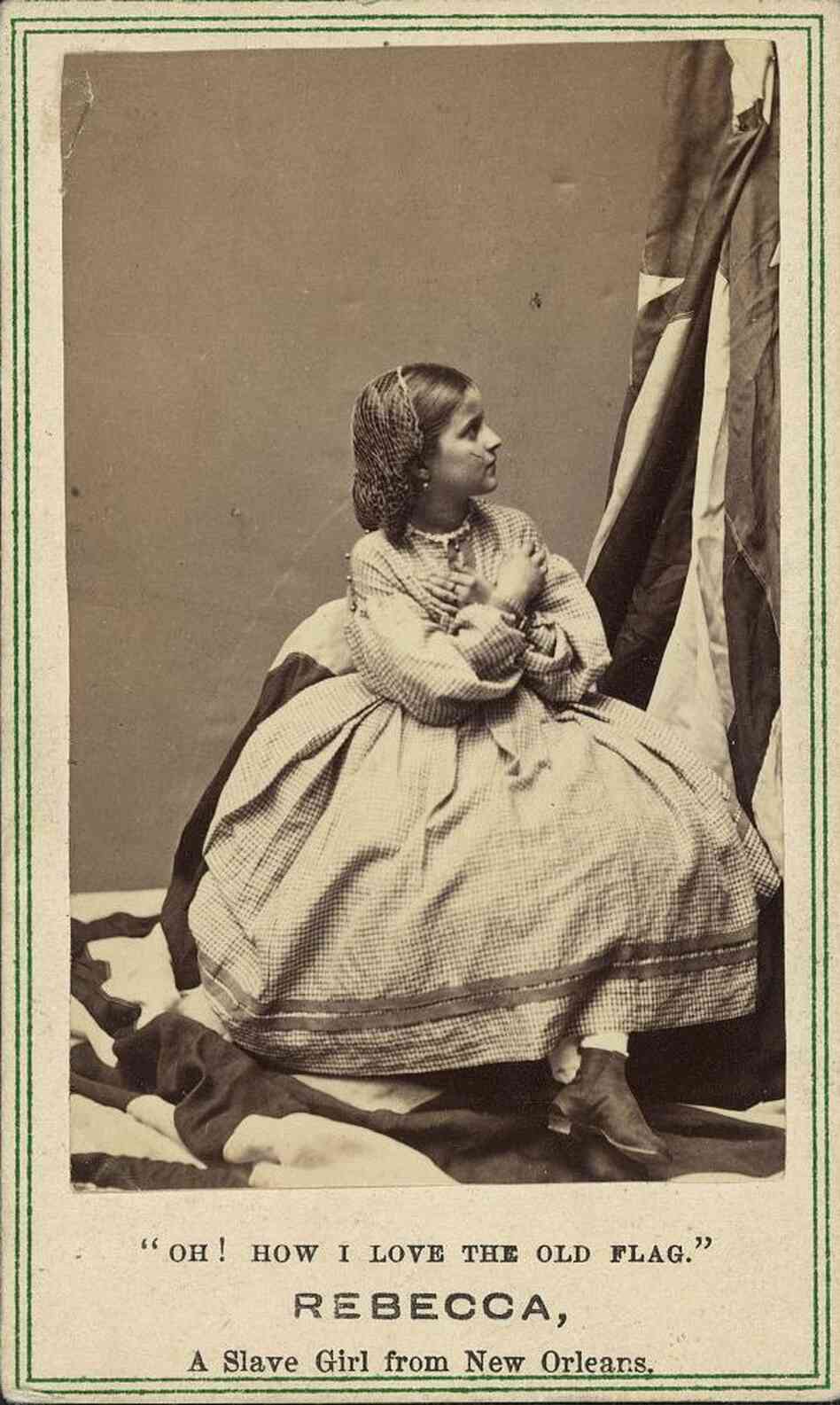 Rebecca Huler, her arms crossed over her chest, while she looks up at the flag.