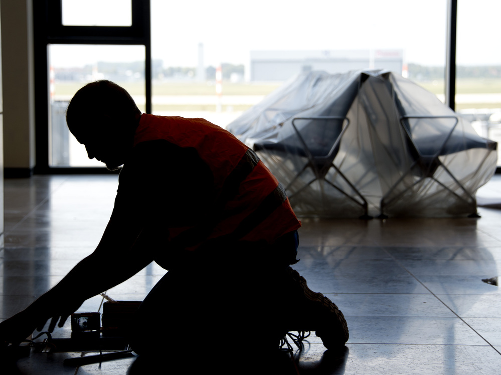 A carpenter works in the unfinished departure hall of the airport on Sept. 11.