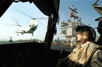 A Navy aviation machinist on the Enterprise watches a Ch-46 Sea Knight fly by after delivering supplies, Oct. 10, 2001. The ship and its carrier battle group were conducting flight operations in Afghanistan following the Sept. 11 attacks.