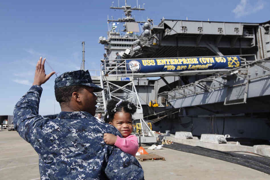 Petty Officer 3rd Class Michael Joseph carries his 1-year-old daughter, Maleah, to his re-enlistment ceremony aboard the USS Enterprise at the Norfolk Naval Station on March 8. The ship began its final deployment on March 11.