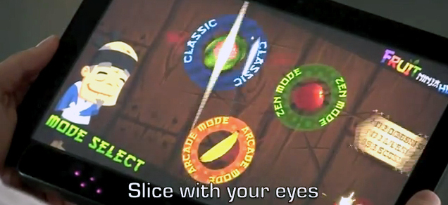 In an image from an Eye Tribe video, a man uses his eyes to play the Fruit Ninja game, slicing fruit in half as it appears on the screen.
