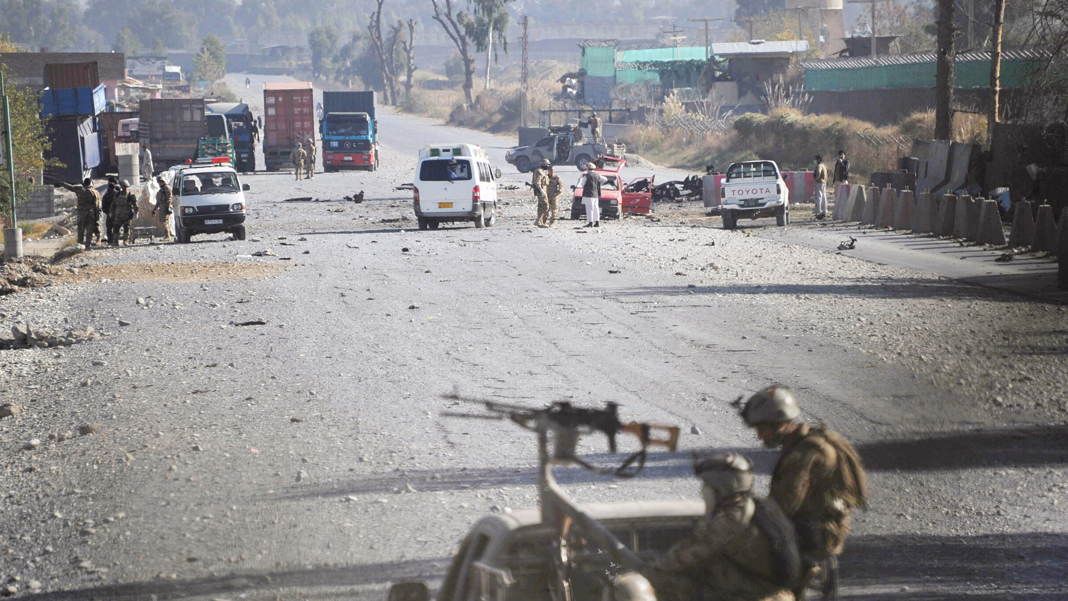 Afghan security forces block the road where Taliban suicide bombers attacked a joint U.S.- Afghan air base in Jalalabad, east of Kabul, Afghanistan on Sunday.